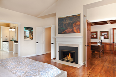 Lopi gas insert in white bedroom with classic mantle